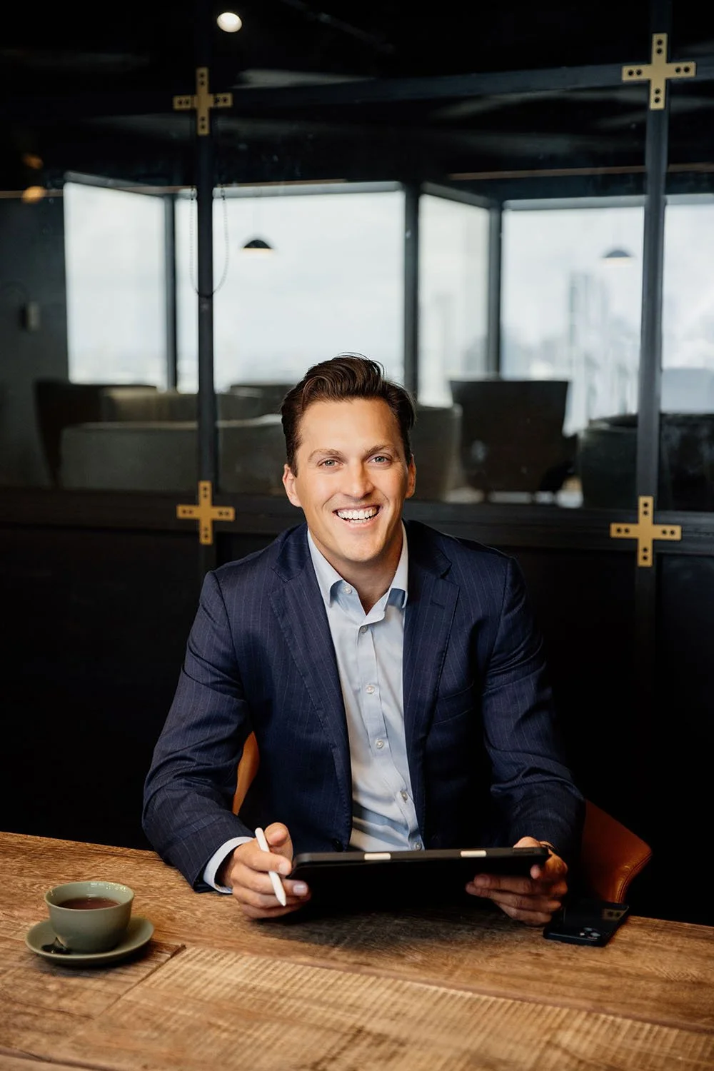 Financial Advisor James Weyler smiling across a wooden table with his tablet in his hands