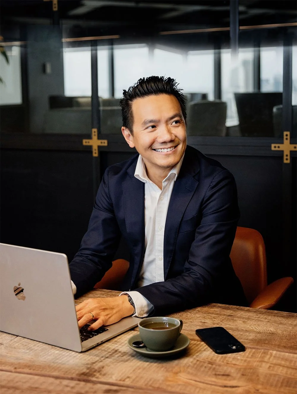Tim Lee at his laptop smiling off camera to his Sydney financial advisor client