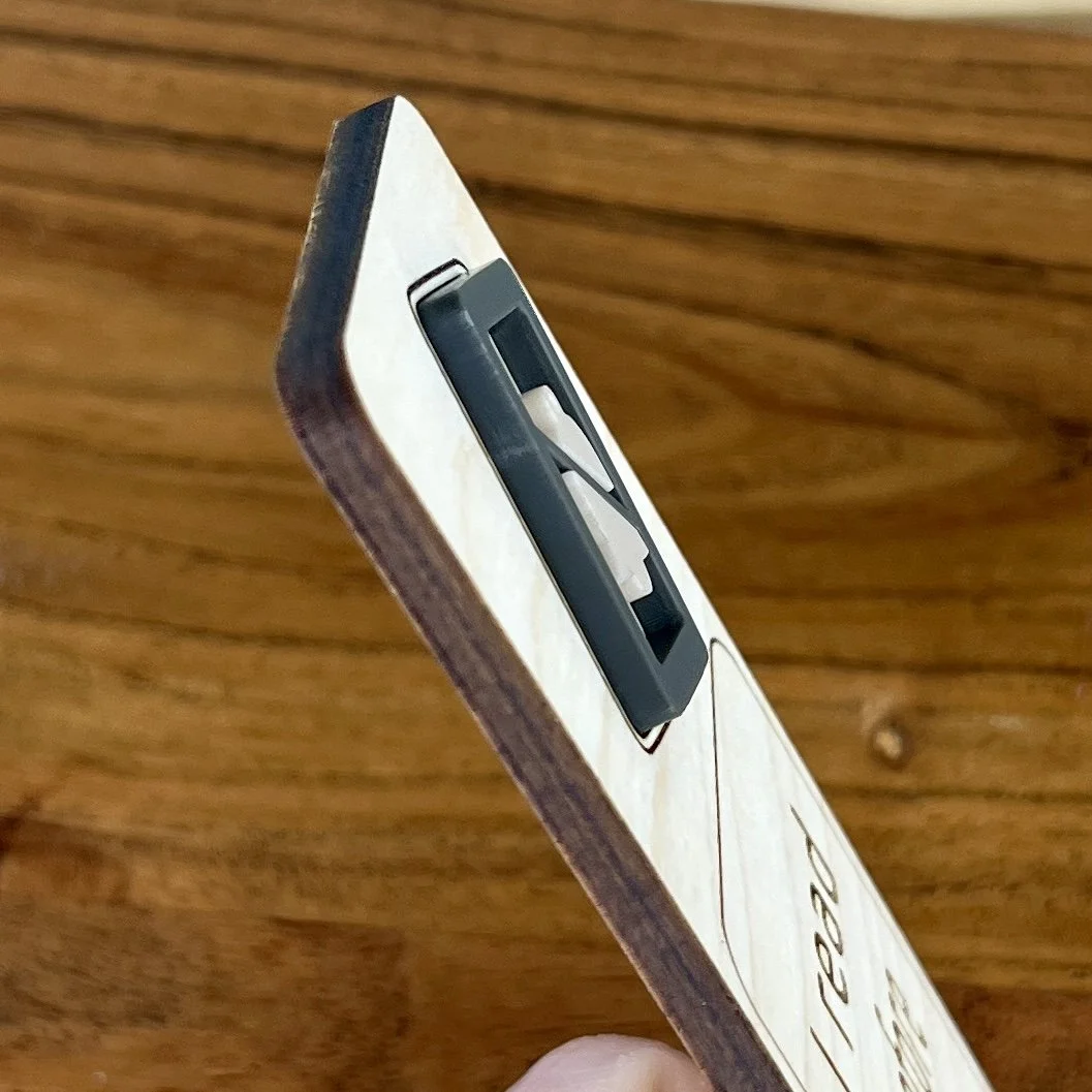 angled view maple bookmark featuring a blue acrylic do not disturb symbol embellishment engraved with the phrase "I read therefore I ignore people".