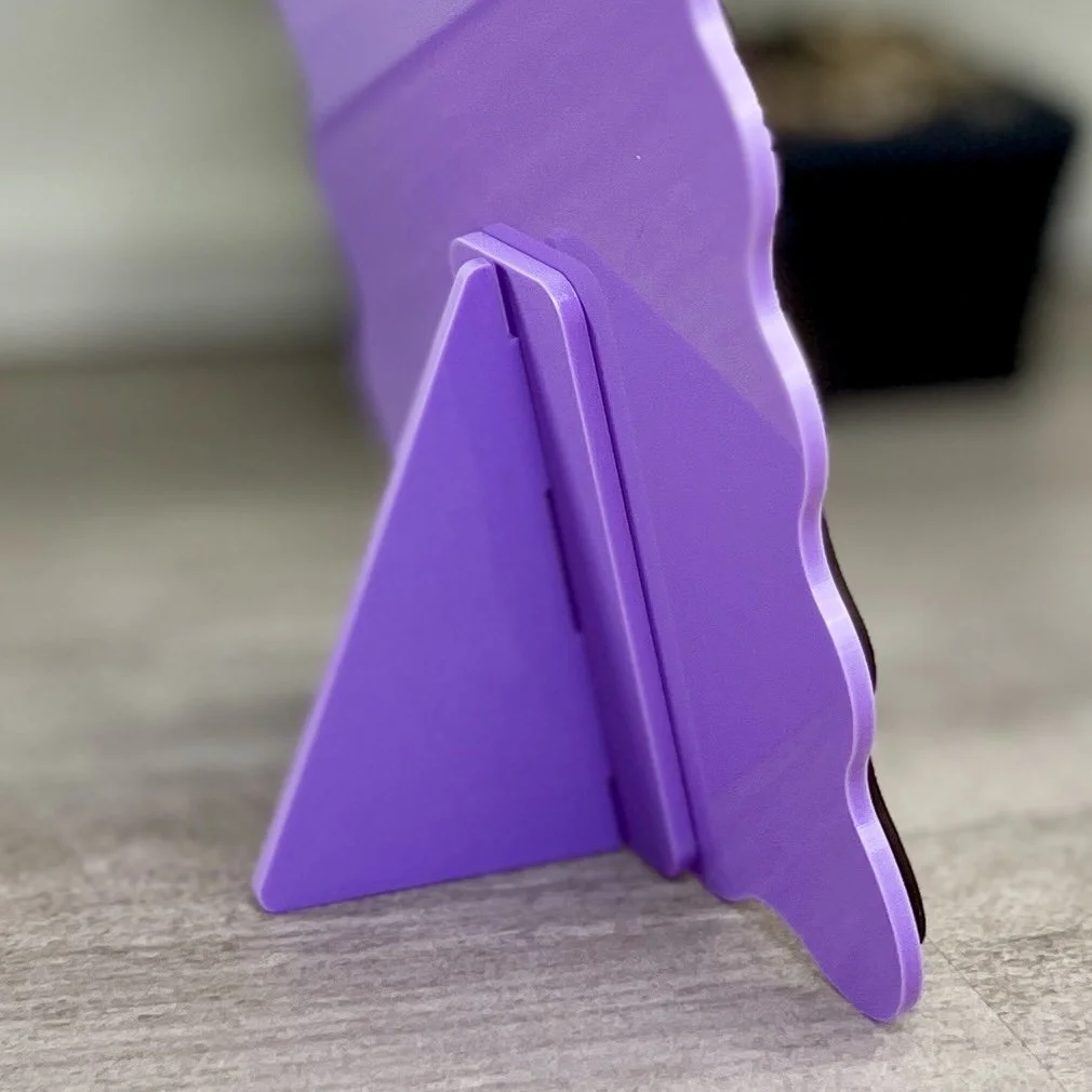 back view of maple wood sign with orchid-coloured acrylic border in a wavy-edged rectangular shape and stand.