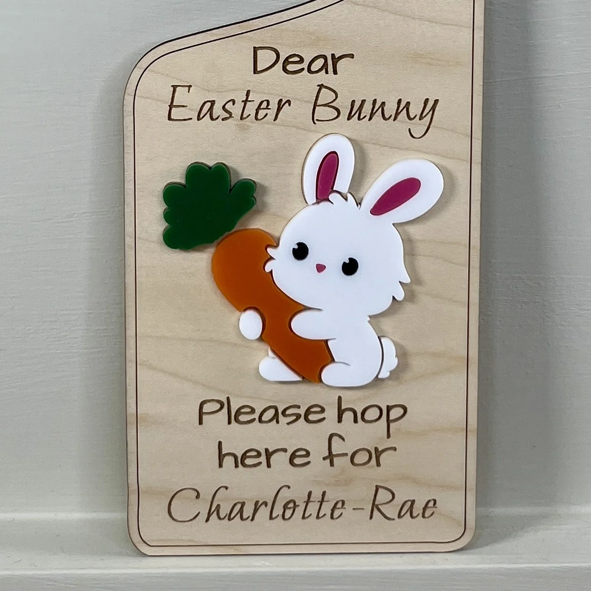 Close up of laser cut maple wood Easter bunny door hanger with raised Easter bunny graphics focusing on the quality of the engraving.