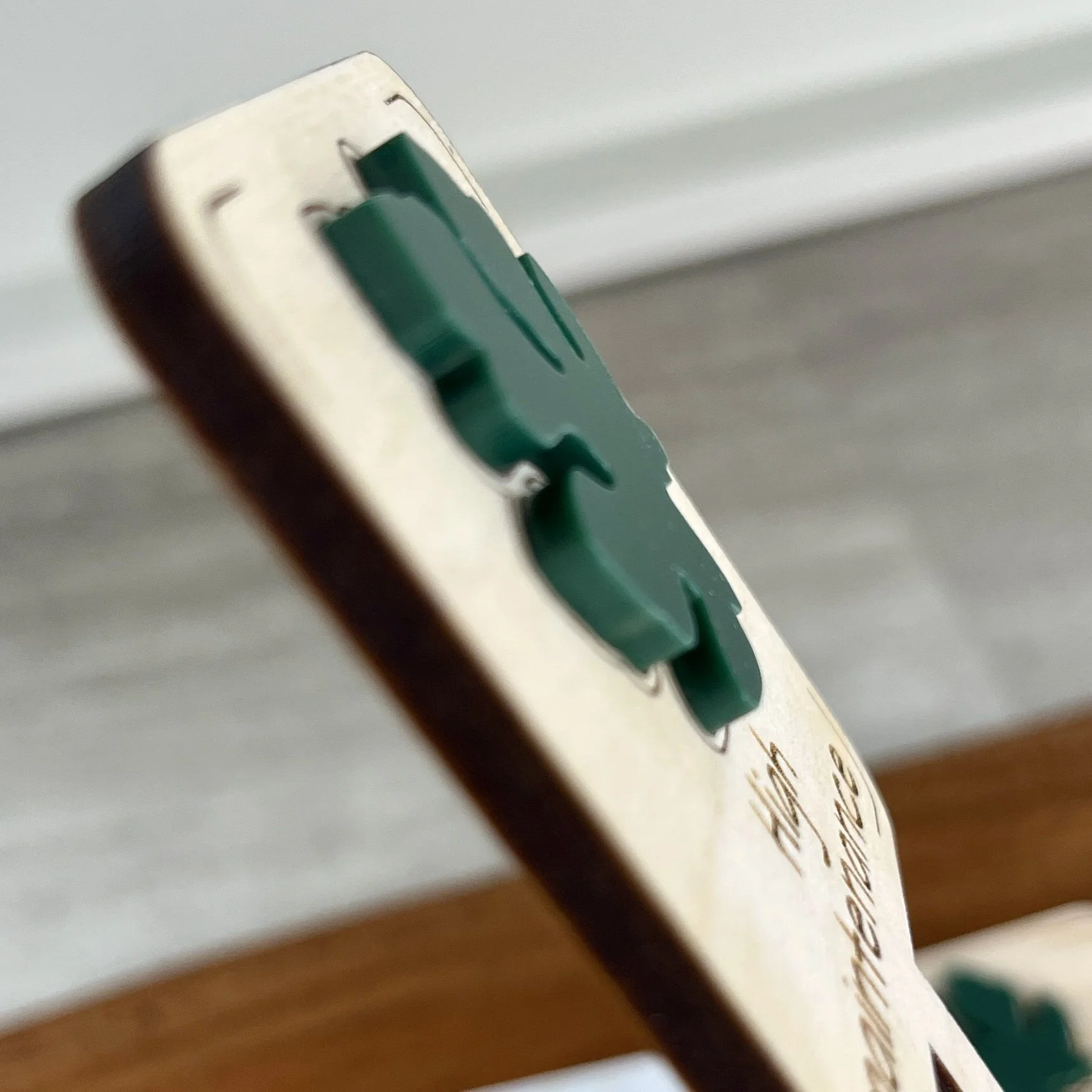 angled view maple plant stake featuring an acrylic tropical leaf embellishment engraved with the phrase "High Maintenance".