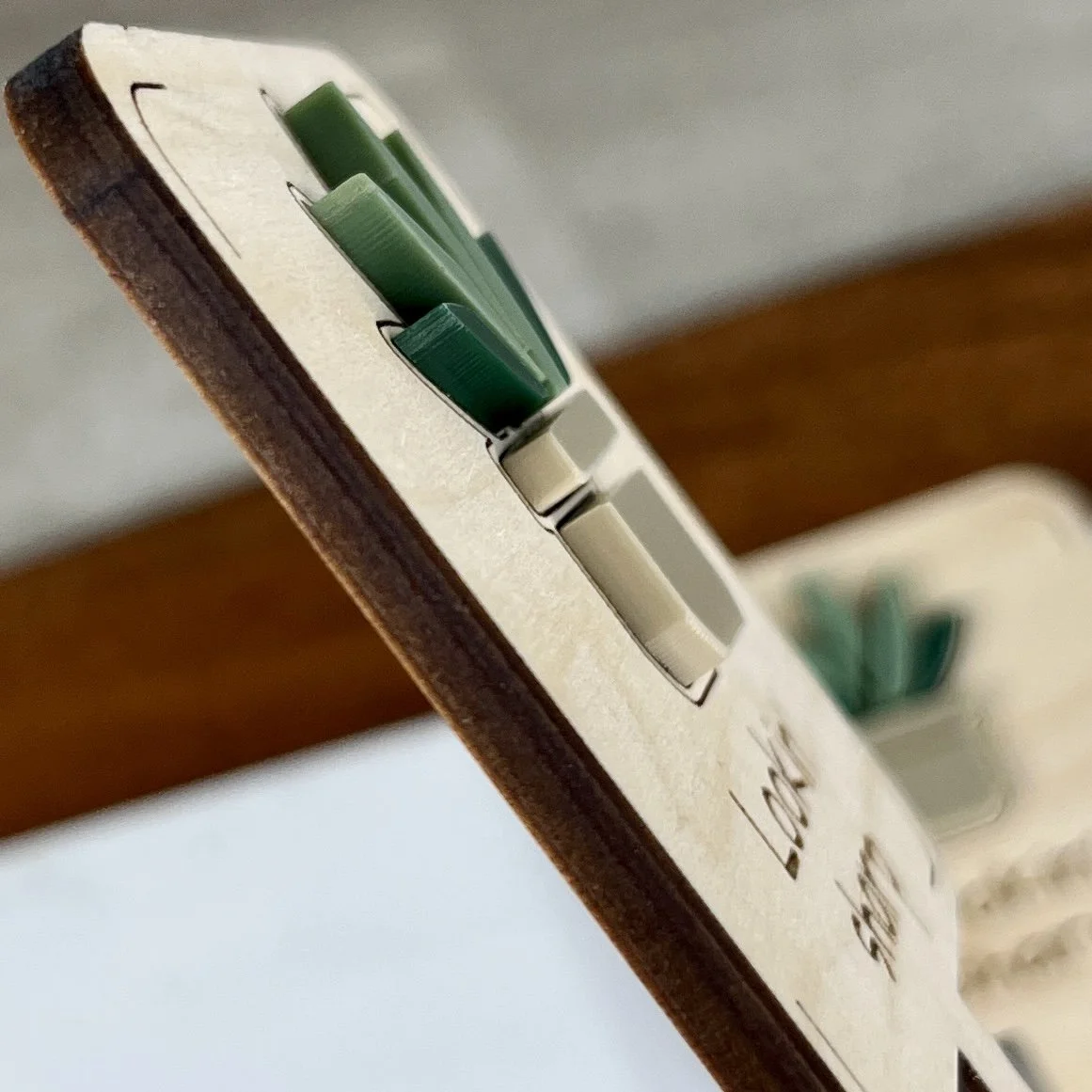 angled view maple plant stake featuring a potted spider plant embellishment engraved with the phrase "Lookin’ sharp".