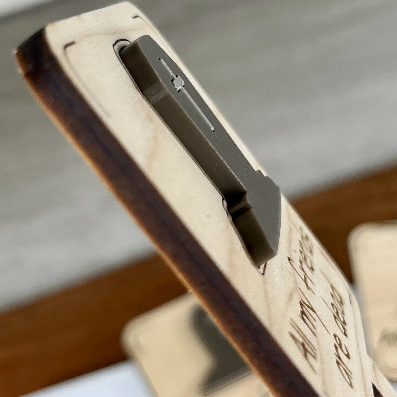 angled view maple plant stake featuring an acrylic espresso tombstone embellishment engraved with the phrase "All my friends are dead".