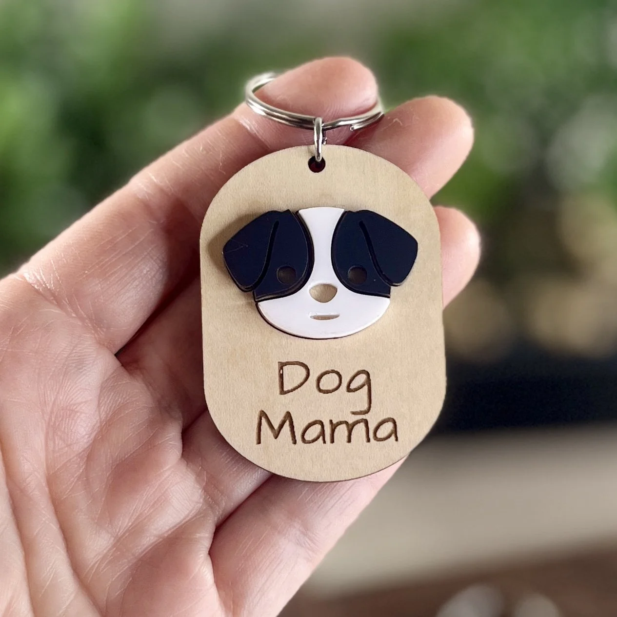 front view laser cut maple wood keychain with black/white dog face that says "Dog Mama"