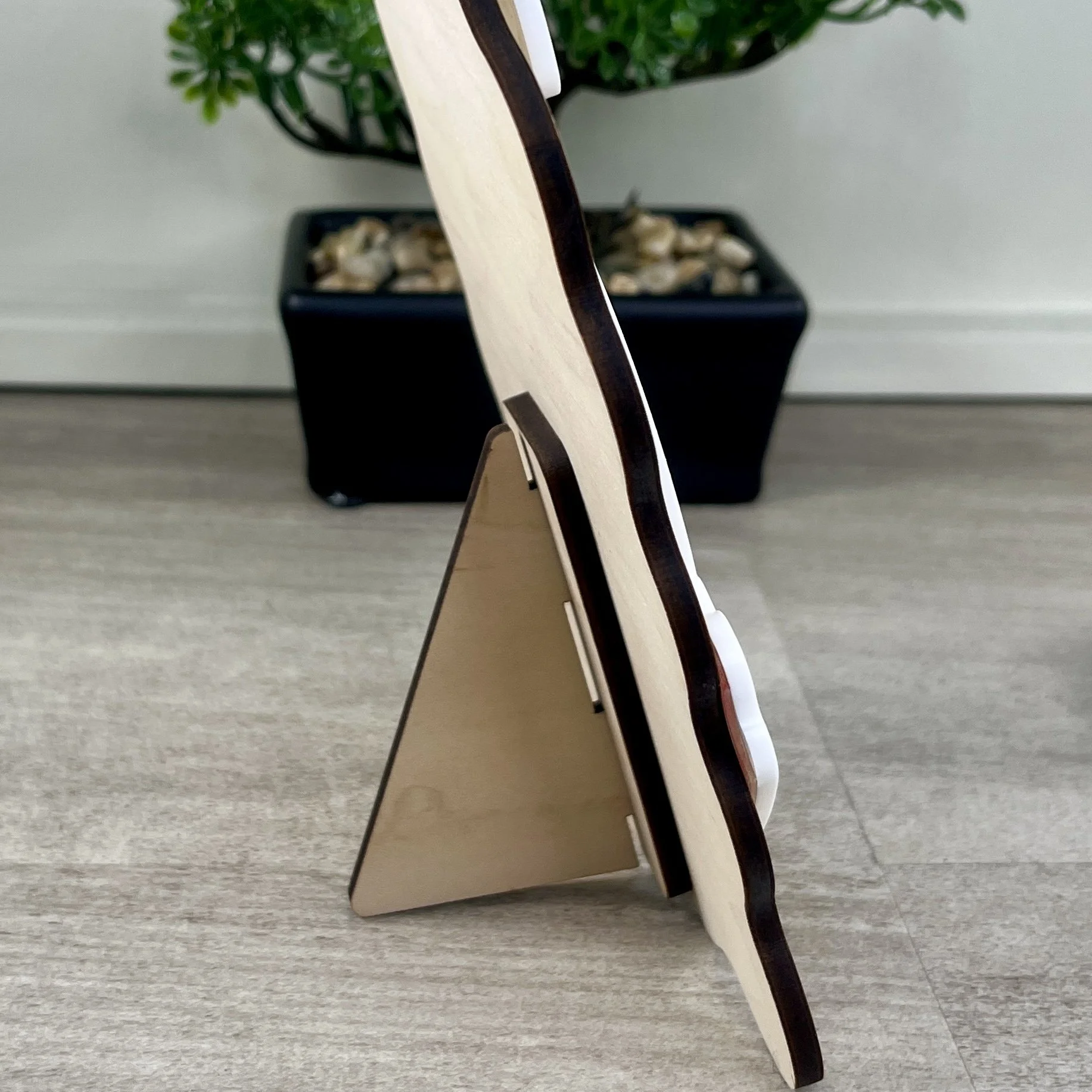 Side view of a maple wood Baby's First Easter photo frame showing built-in stand.