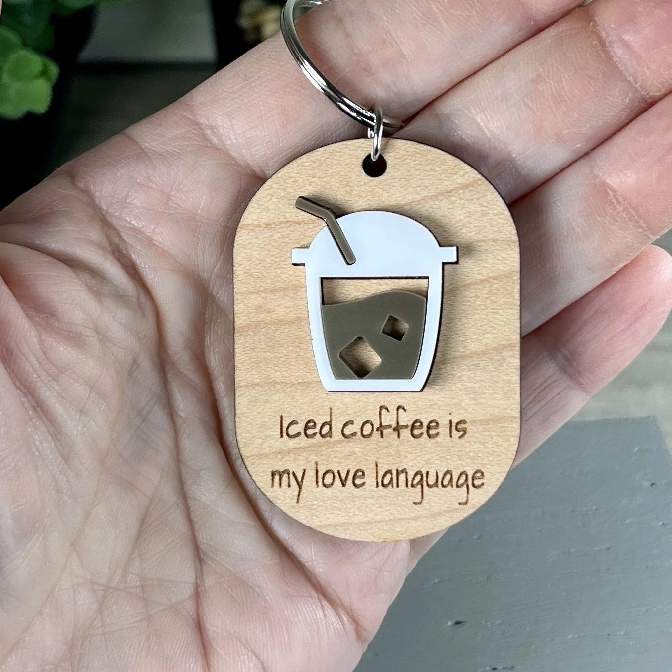 handheld laser cut maple keychain showing iced coffee graphic in raised matte white/espresso acrylic and engraved with "Iced coffee is my love language".