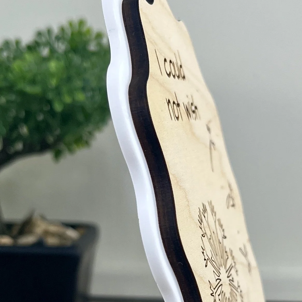 side view of maple wood sign with a white acrylic border in a wavy-edged rectangular shape highlighting the depth and texture of the product.