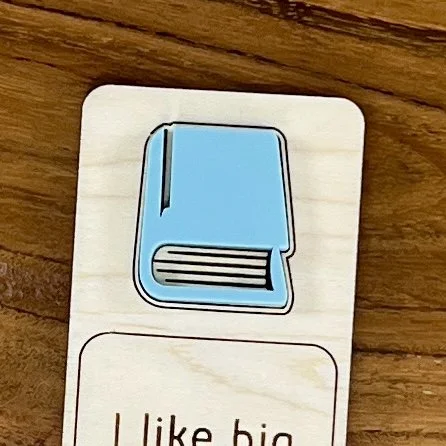 close up maple bookmark featuring an acrylic book engraved with the phrase "I like big books and I cannot lie”.