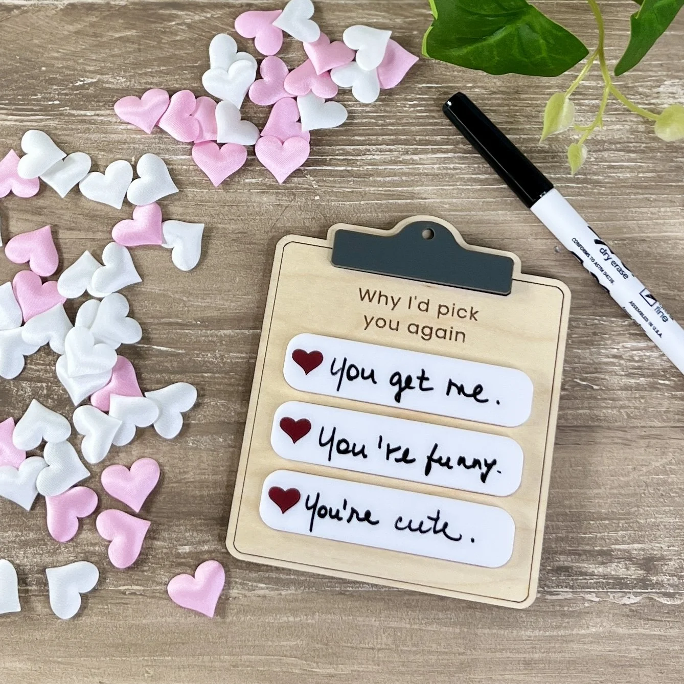 Clipboard-shaped maple wood magnet with three dry-erase note sections filled in to demonstrate how to use.