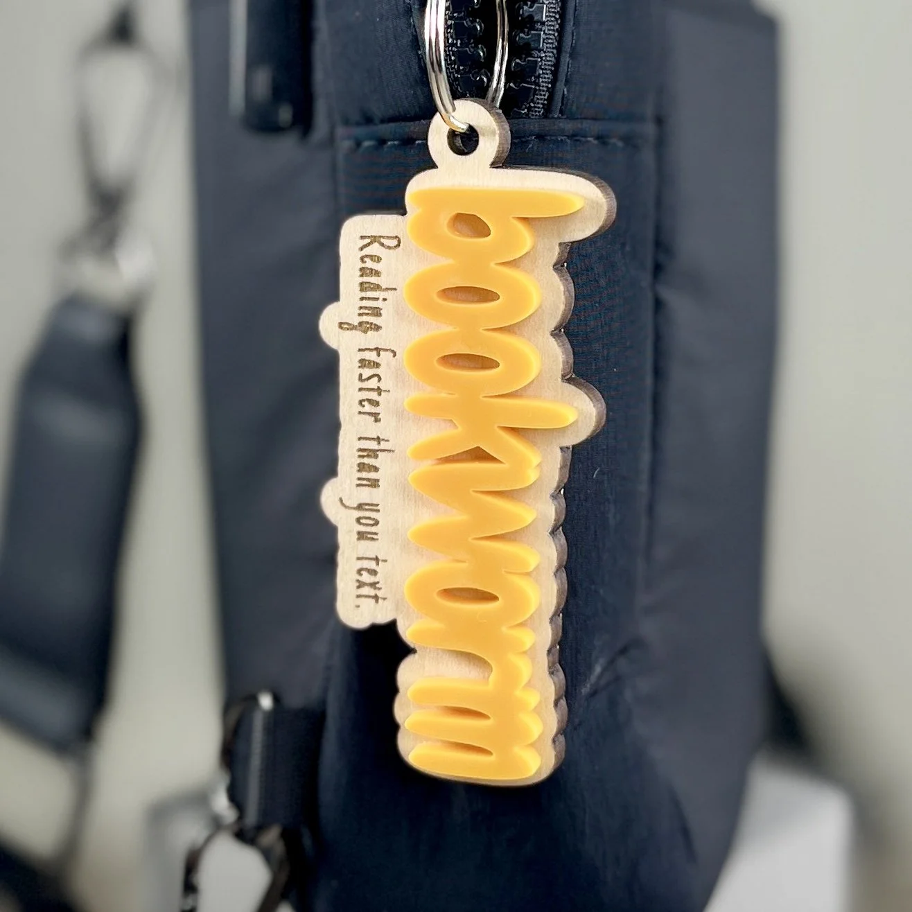 lifestyle shot laser cut maple wood backpack tag bumblebee yellow acrylic "Bookworm" book lover gift