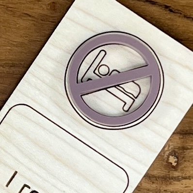 close up maple bookmark featuring a mauve no bedtime symbol embellishment engraved with the phrase "I read past my bedtime".