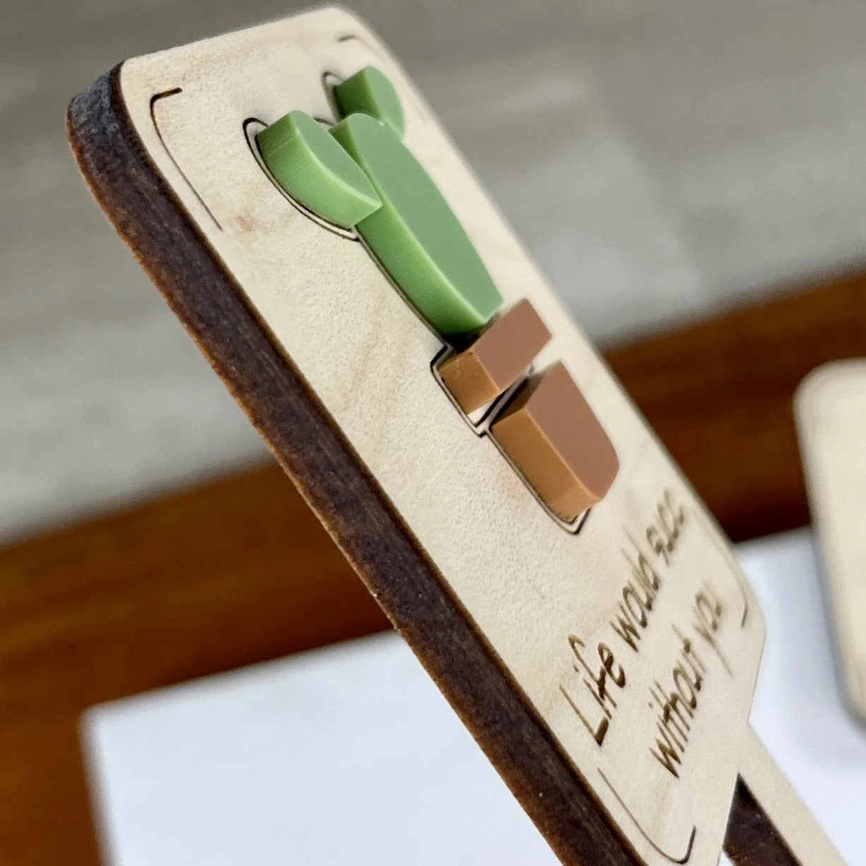 angled view maple plant stake featuring a potted succulent embellishment engraved with the phrase "Life would succ without you".