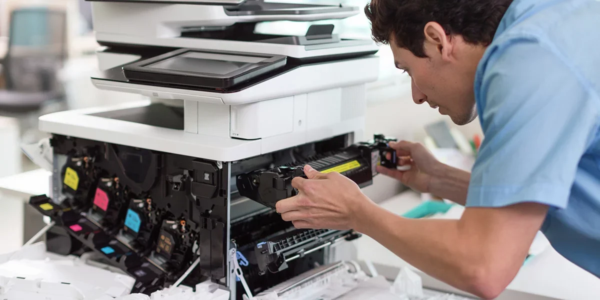 IT technician working on a laptop in a server room
