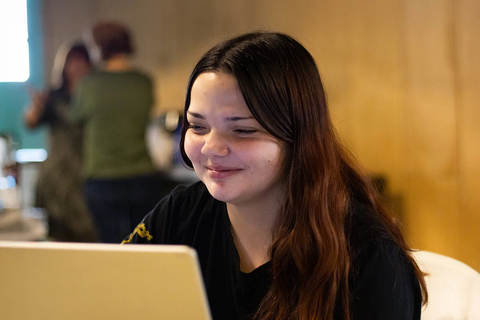 Teen girl working on a laptop in a library setting, showcasing Grace Place School’s job skills program that builds real-world digital and professional capabilities.
