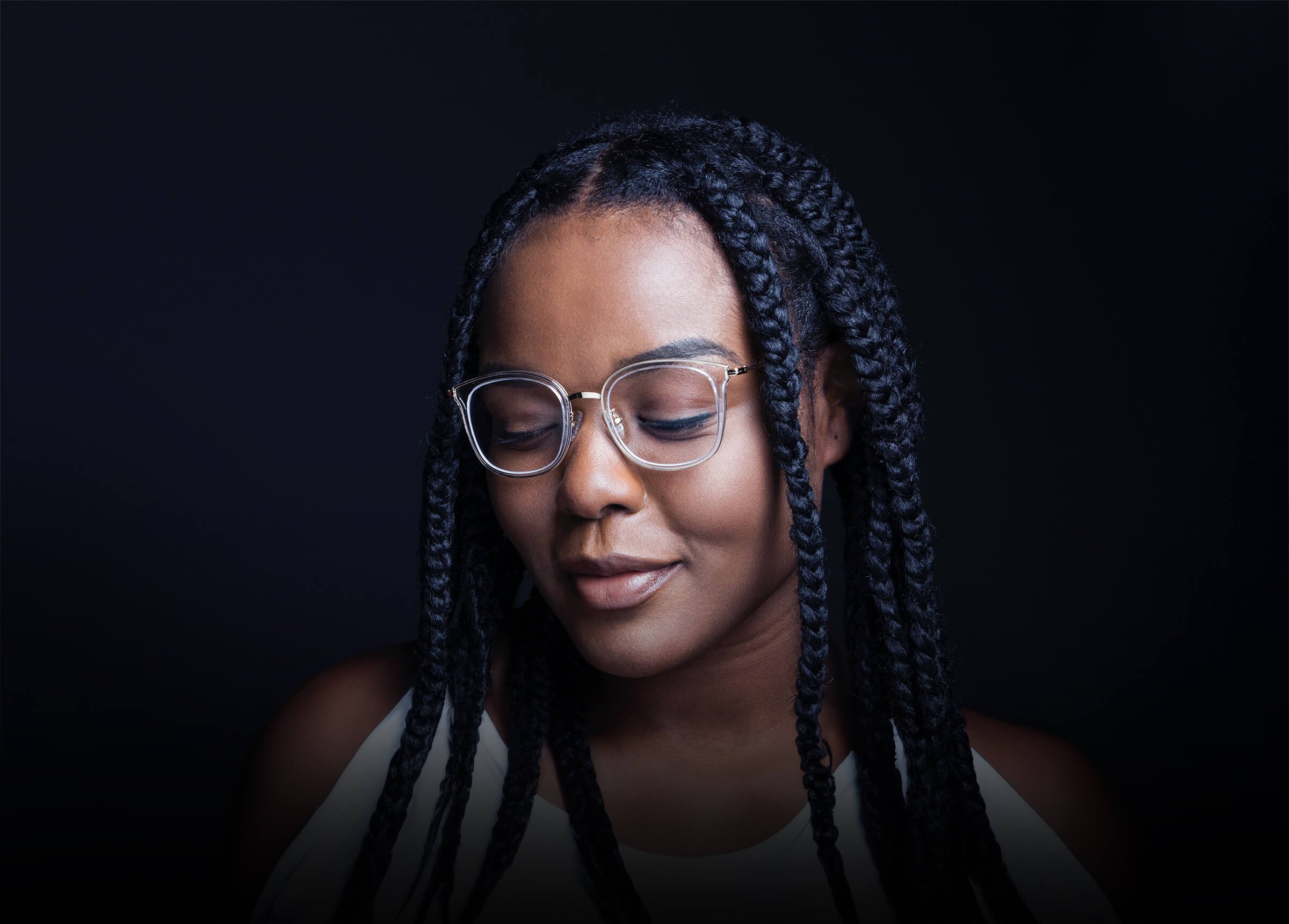 Elisha, a Grace Place School alumna, pictured looking down with a thoughtful smile—reflecting on her journey of growth and mentorship.