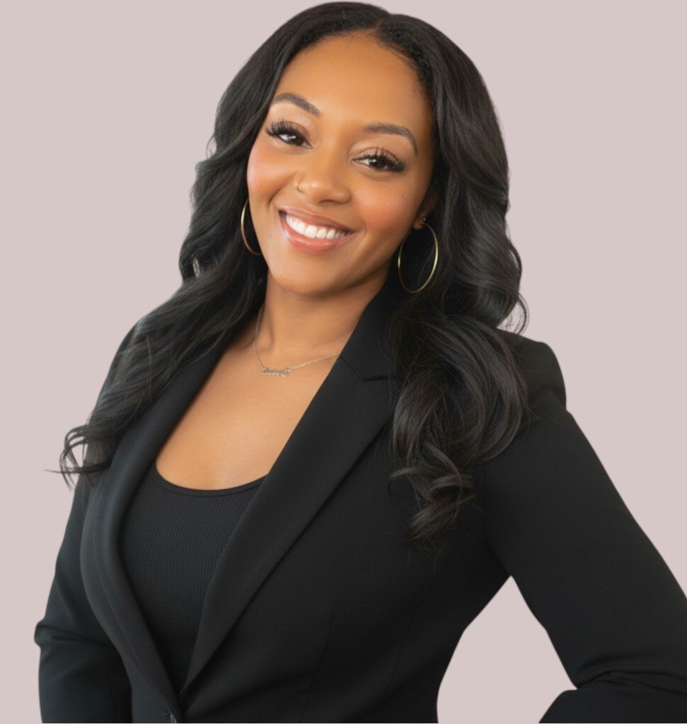 Erica Swain, MSW, LISW, a Black therapist in Cincinnati, Ohio offering neurodivergent-affirming care. with long black hair, wearing large hoop earrings, a black blazer, and a black top.