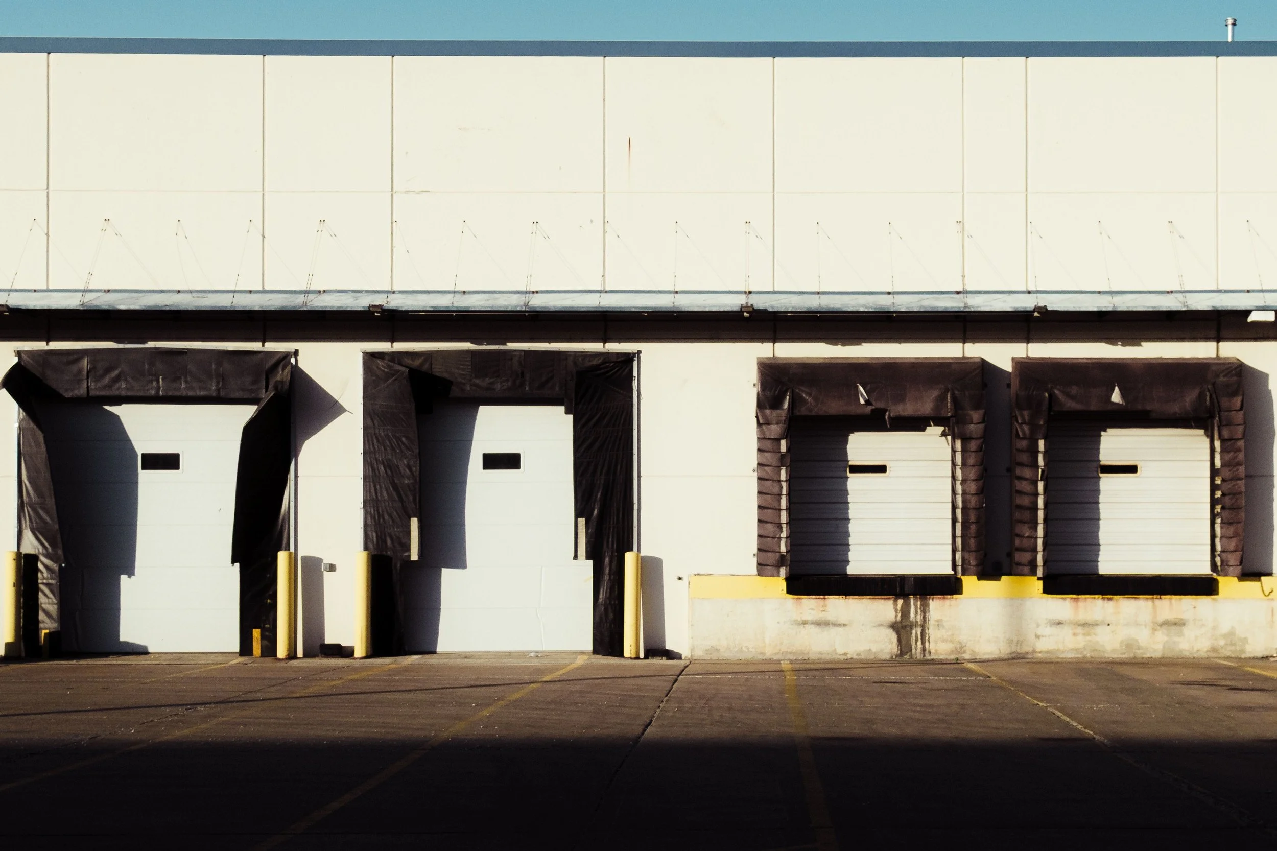 Modern concrete warehouse with loading dock doors in afternoon sunlight