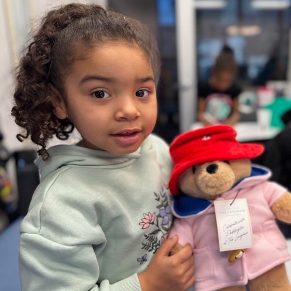 Small girl holding Paddington Bear, at our clinic in 2025