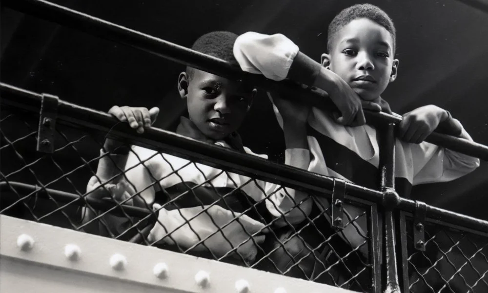1950s: Two boys looking over the railing onboard the ship