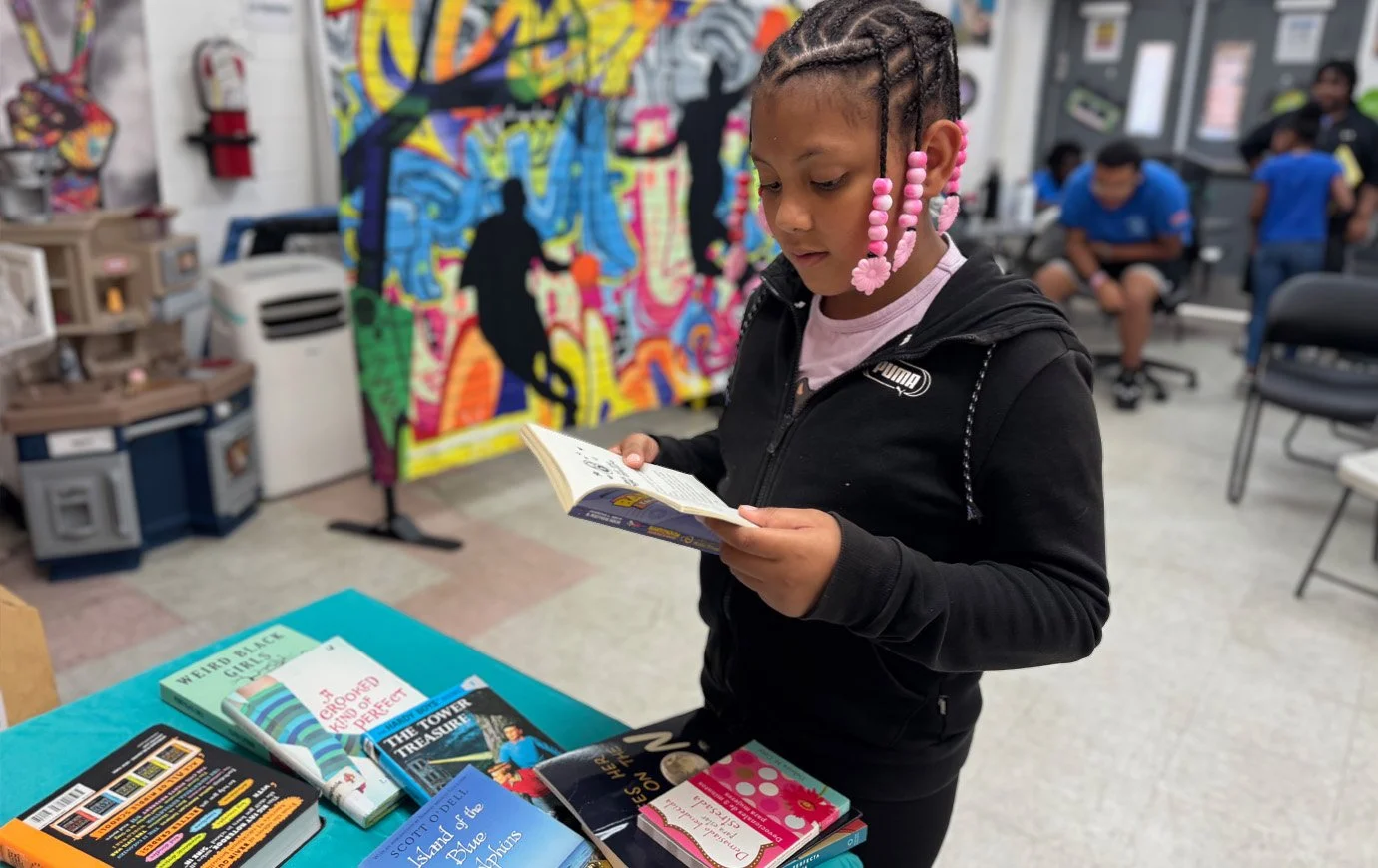 An older girl reads the opening pages of a fun book
