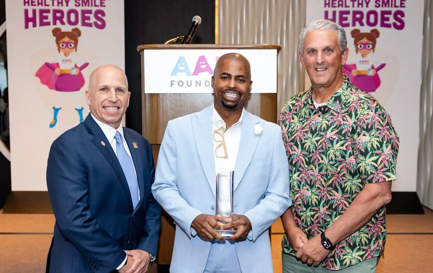 Dr. Mario Ramos, Immediate Past President of the AAPD Foundation (President at the time), along with Ernesto and Mr. Kevin Thomas from Elevate Oral Care, the award sponsor. Photo: Vito Amati