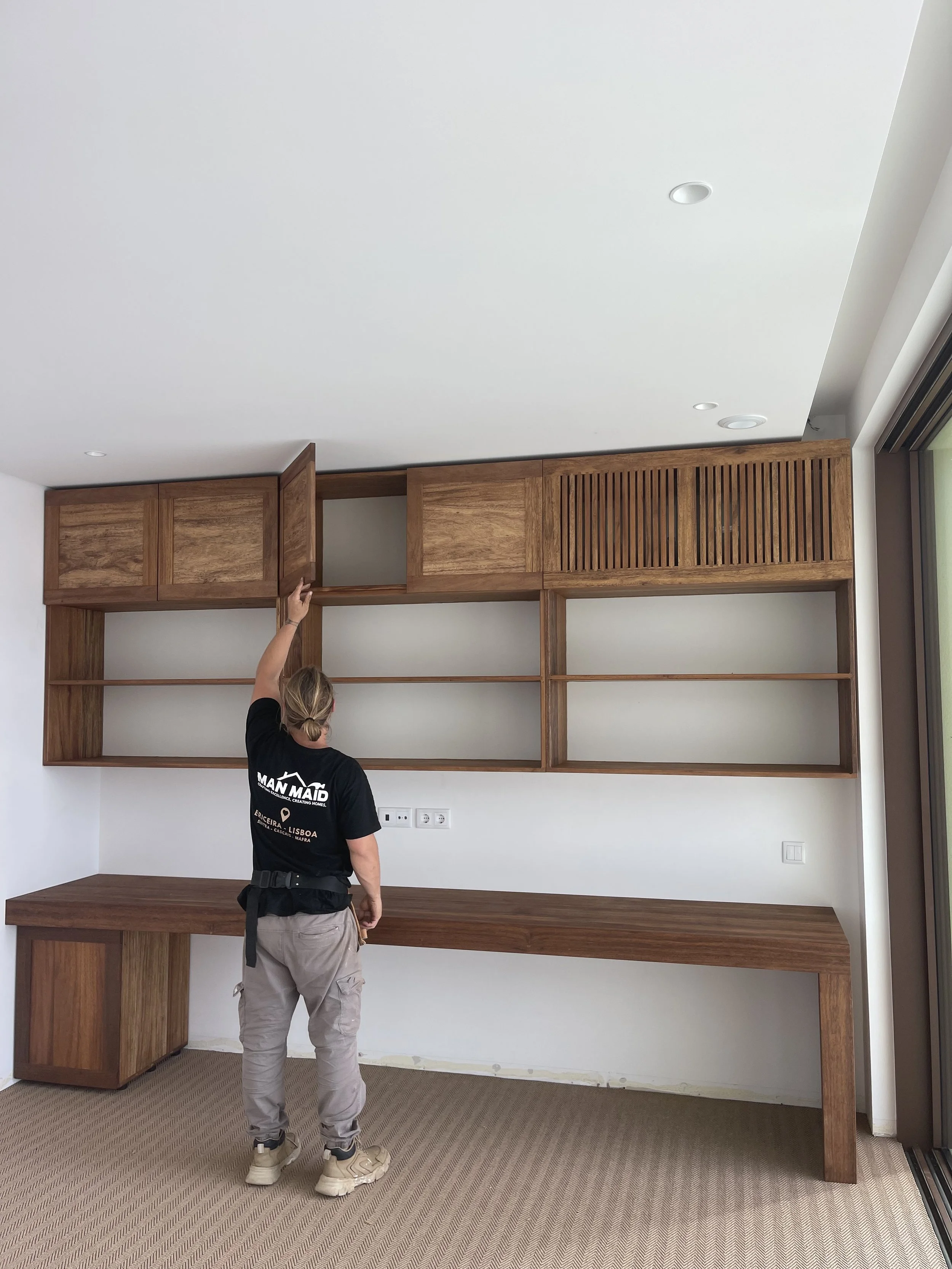 Installing a solid-wood office storage system with a wooden desk and storage shelving.