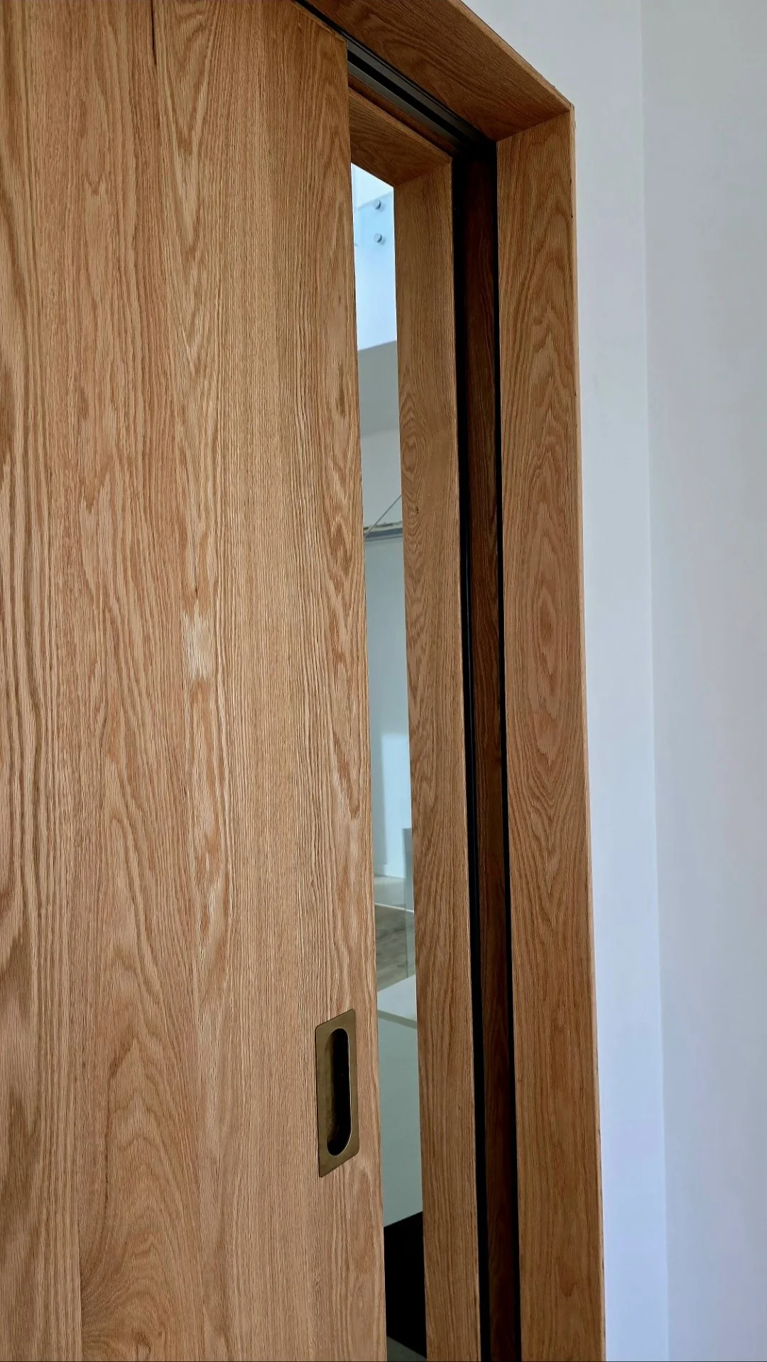Close-up of handcrafted solid oak sliding door detail with acoustic sealing features