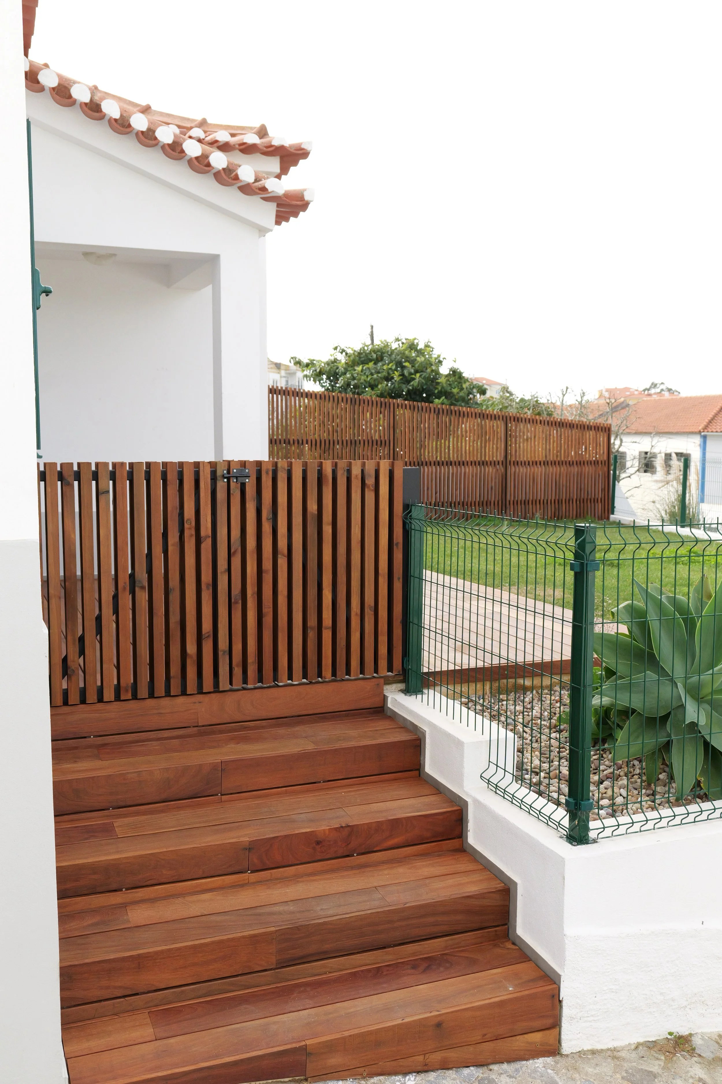 Custom wooden fence with high-quality Ipe decking installed in a modern garden.