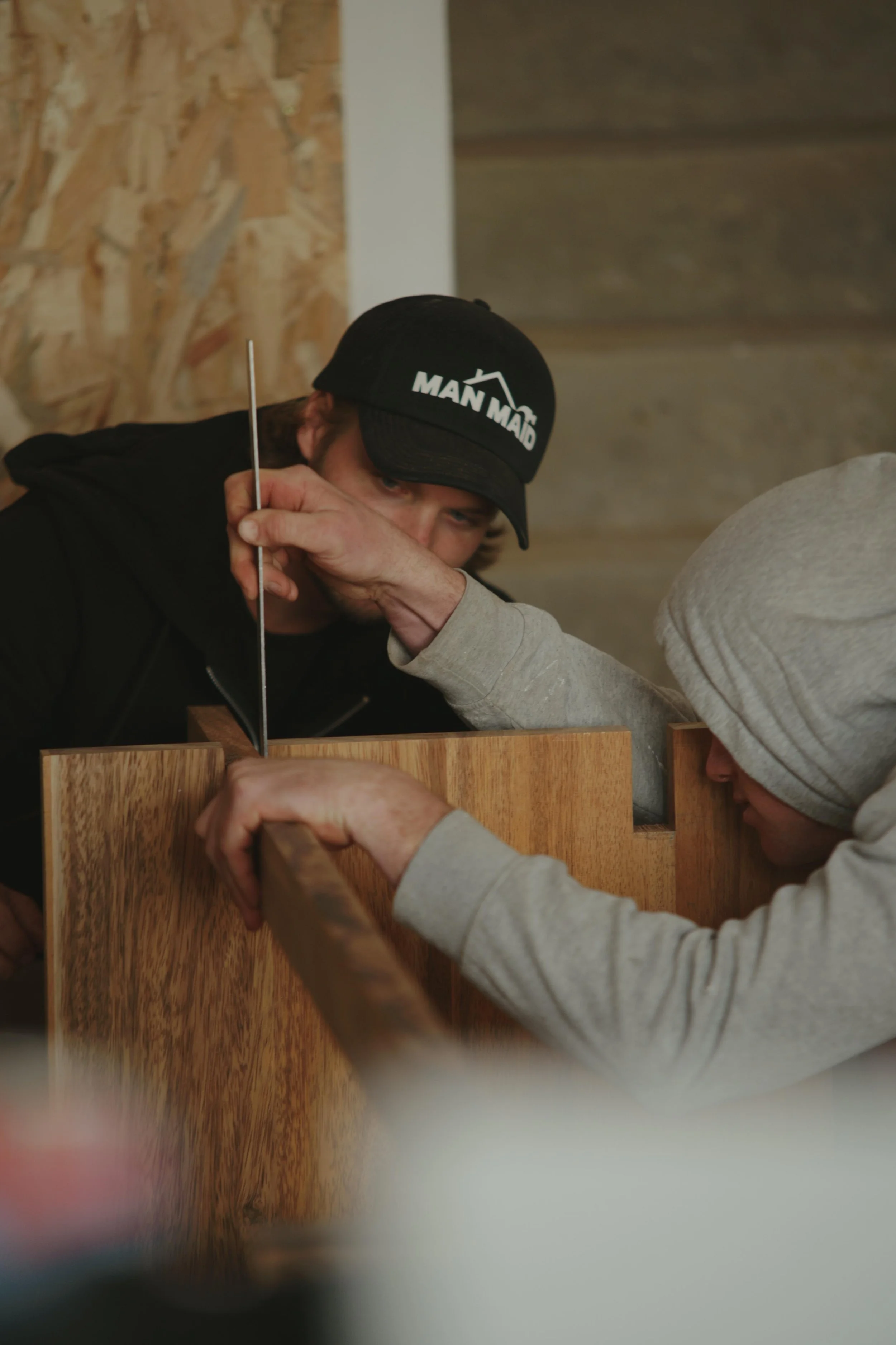 Two participants building a solid-wood project with exotic hardwood during a ManMade workshop