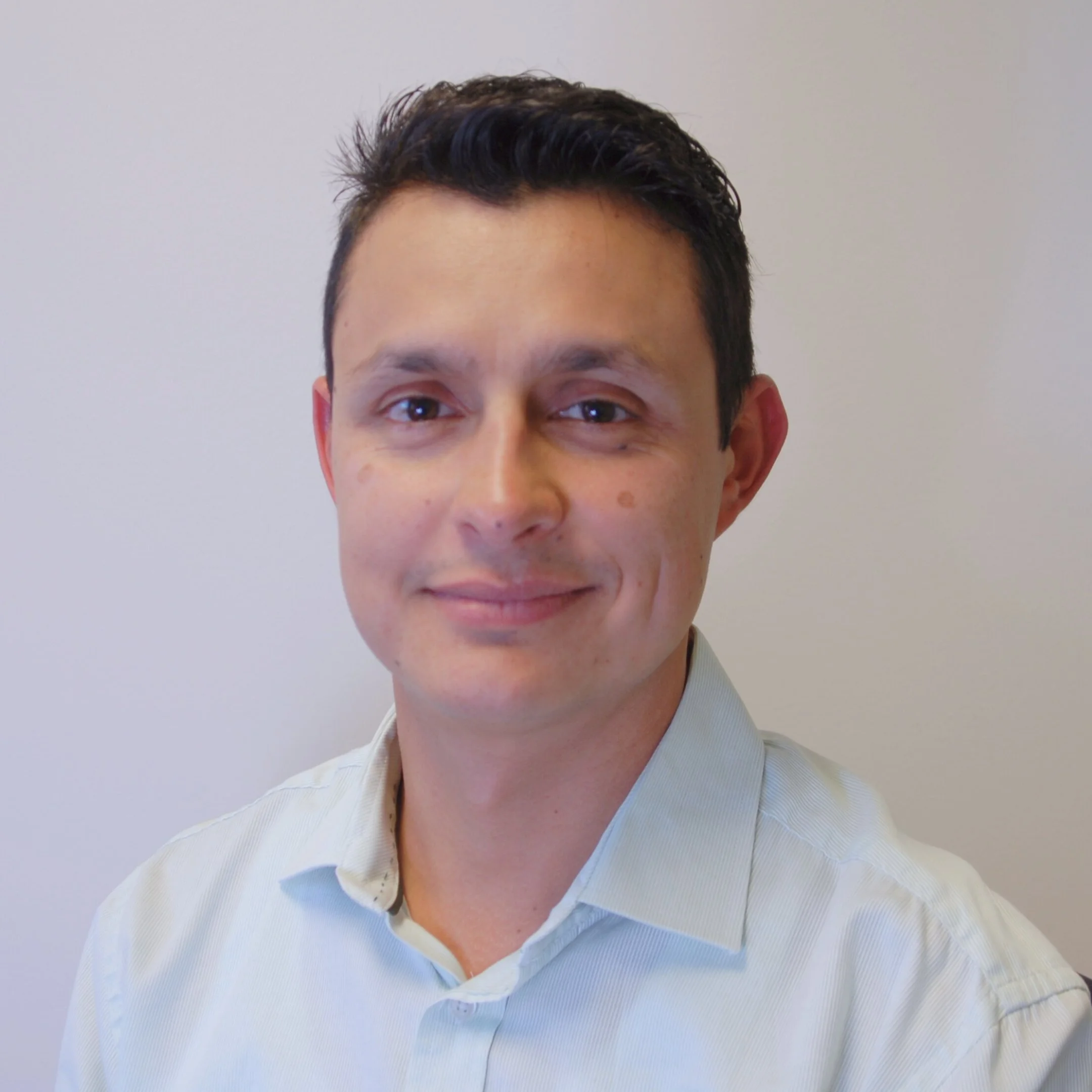 AlignWorks Solutions Founder & CEO Diego Medina. A man with short dark hair and a light shirt smiling against a plain light background.