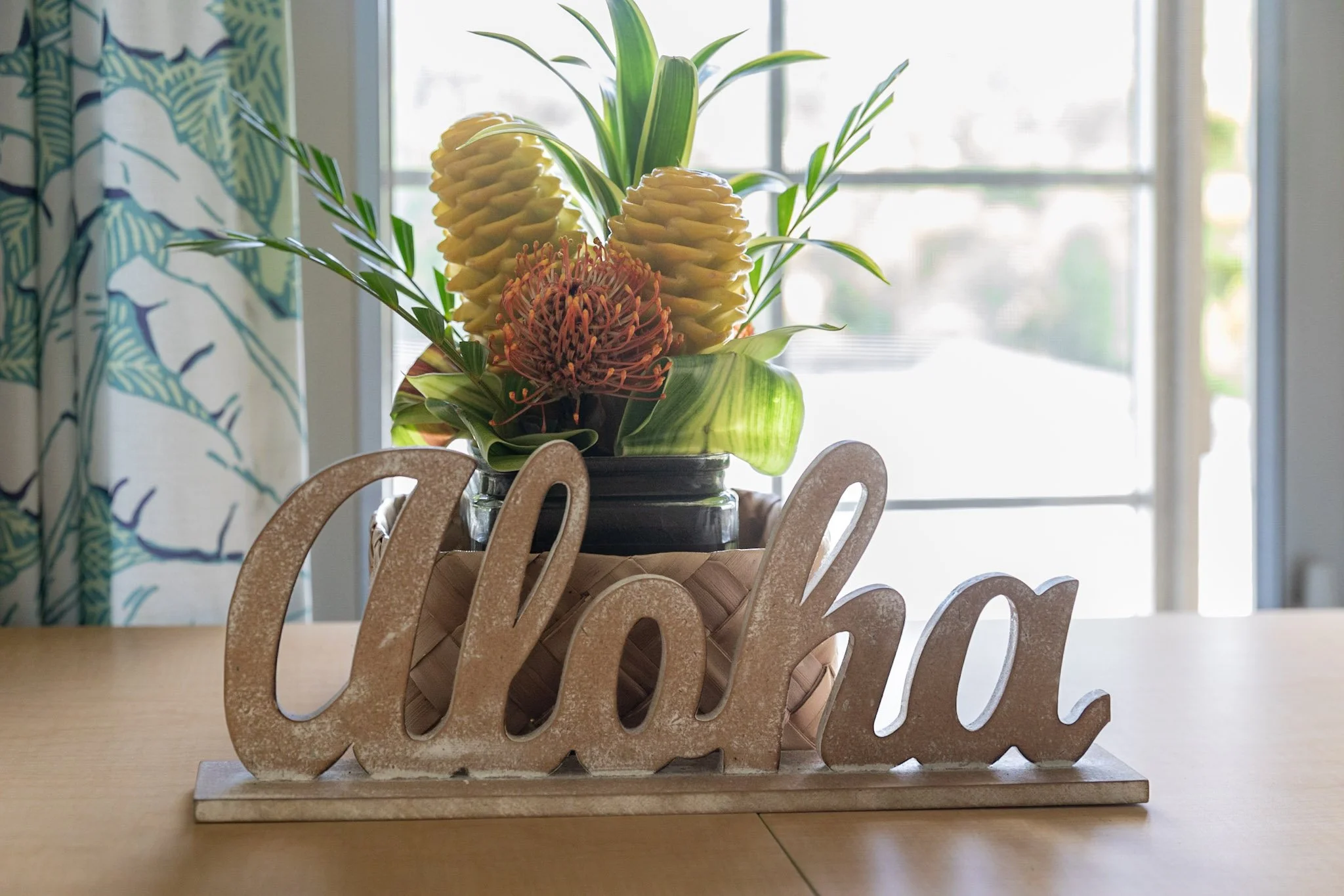 Wooden cutout standing figure spelling 'aloha'