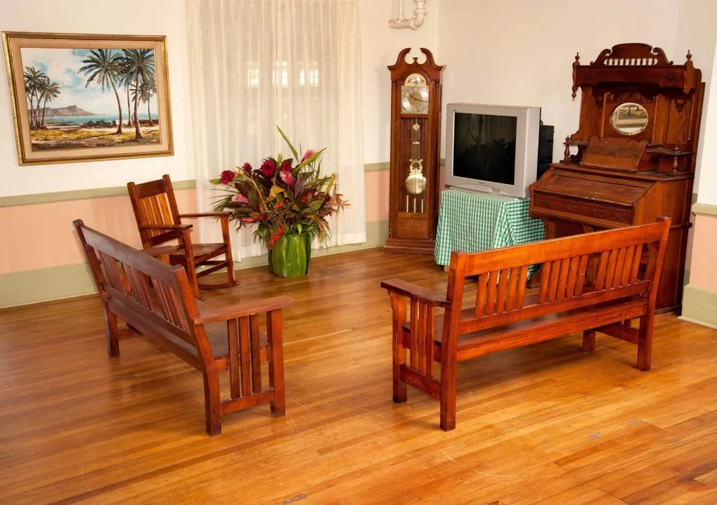 At the heart of the Home, the “Koa Room” features koa furniture and a fireplace adorned with a portrait of King Lunalilo.
