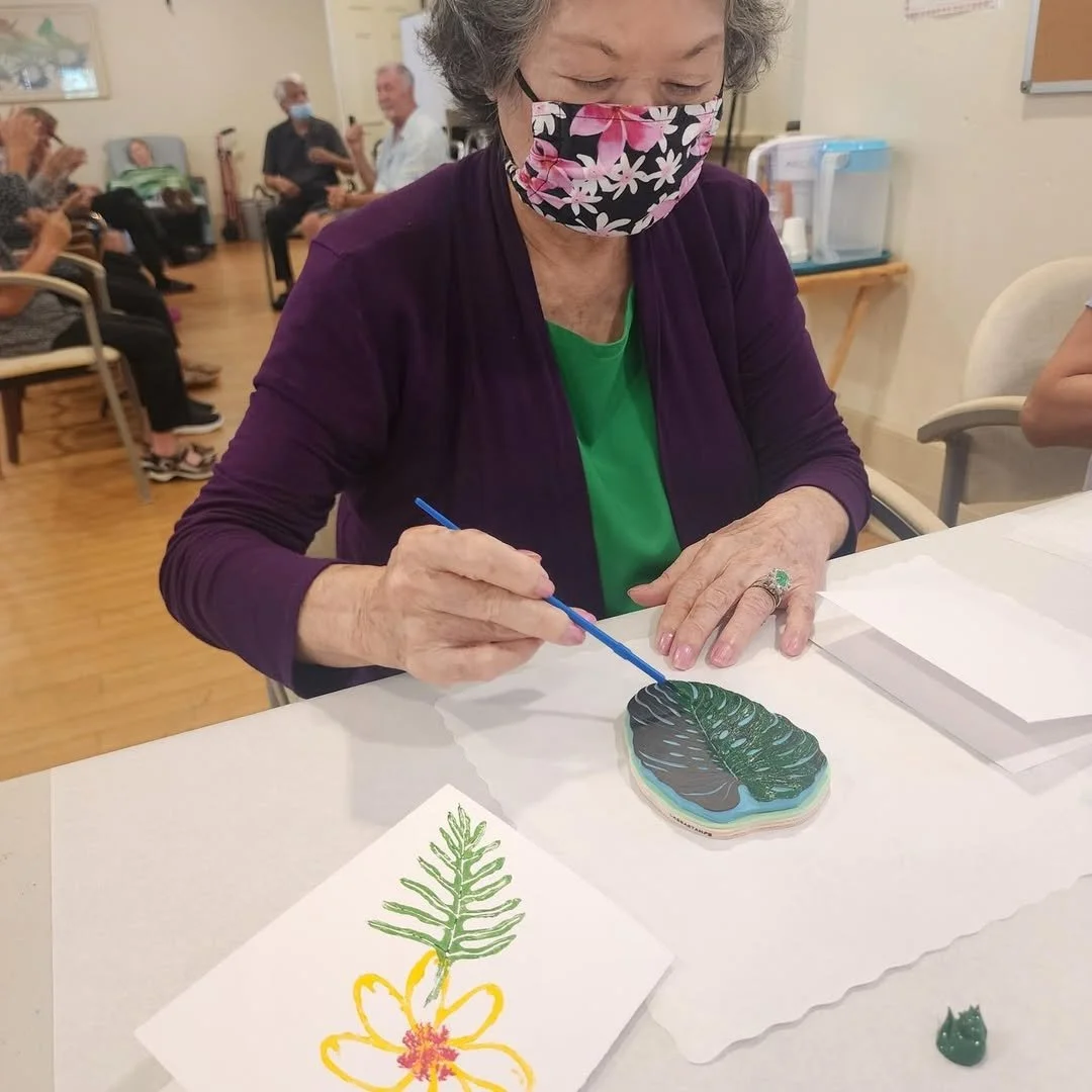 Kūpuna participating in a painting activity within the Adult Day Center