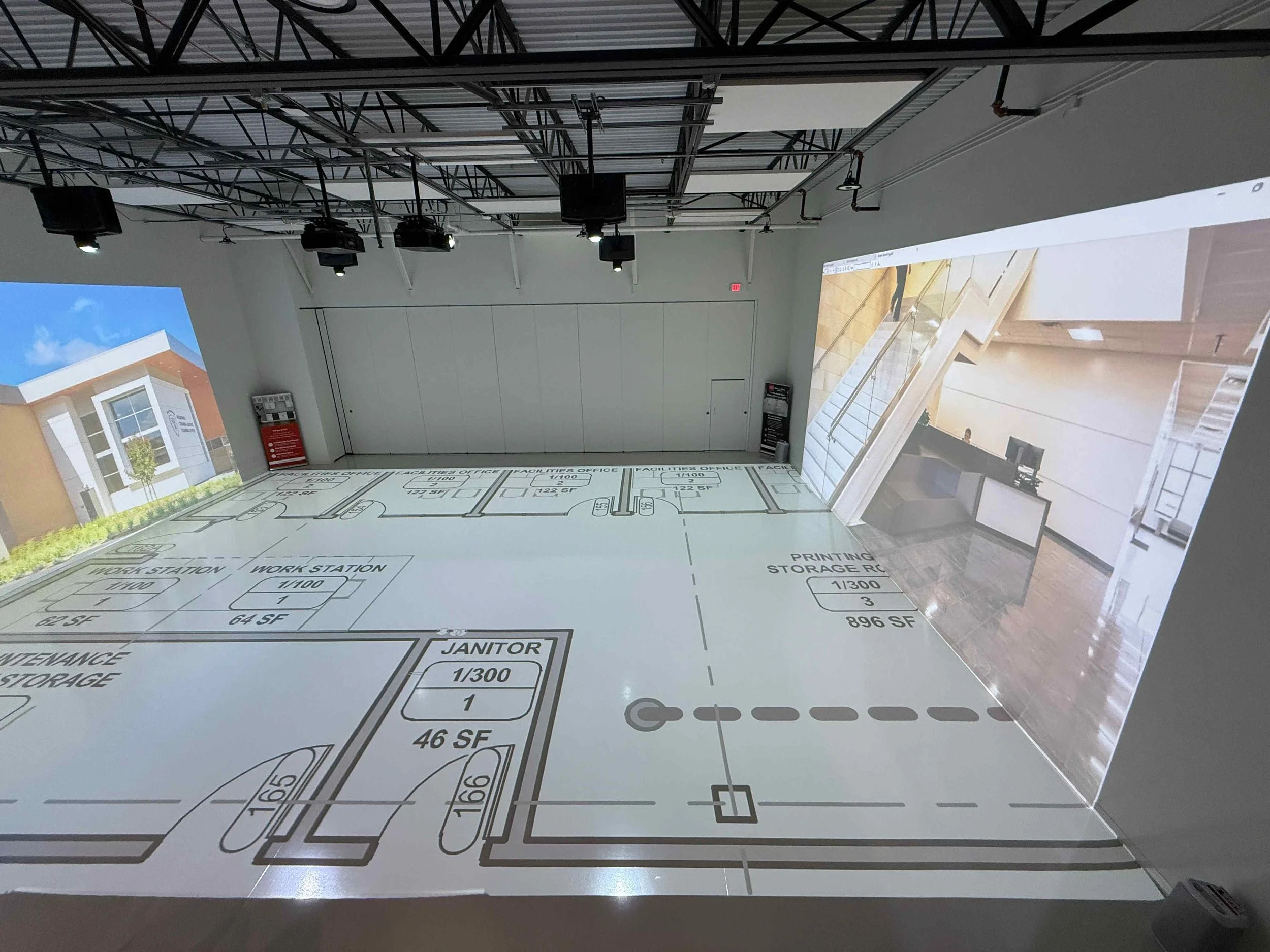 Interior of a room with projectors displaying architectural floor plans and real estate images on the walls and floor.