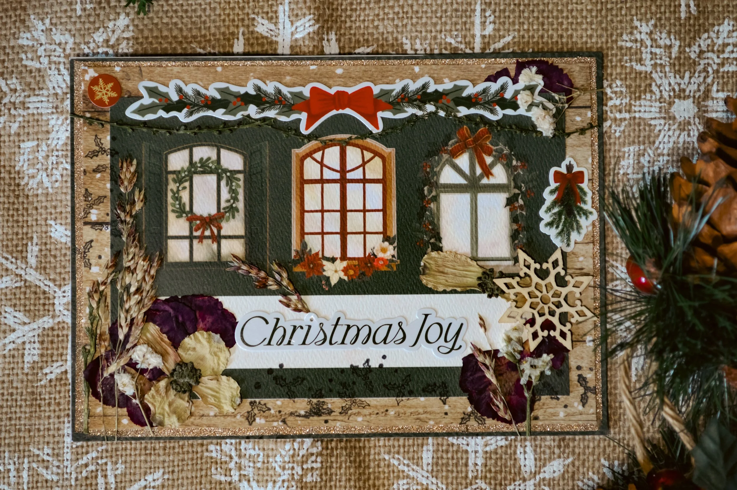 handmade window christmas card with pressed flowers and other embellishments