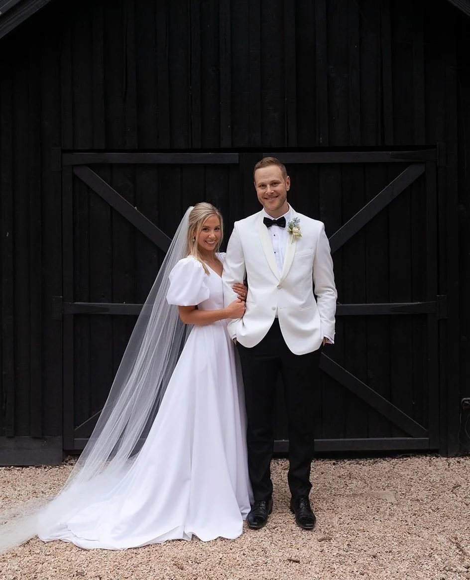 bride-and-groom-smiling-in-front-of-black-timber-wall-at-kwila-lodge-gold-coast.jpeg