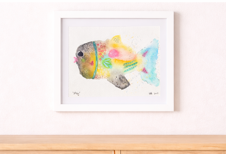 Colorful watercolor painting of a fish with vibrant patterns and details on white background, framed and hanging on a wall.