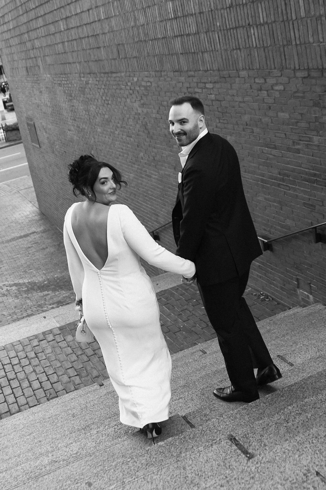 Bride and groom walking down steps after eloping at Boston City Hall.
