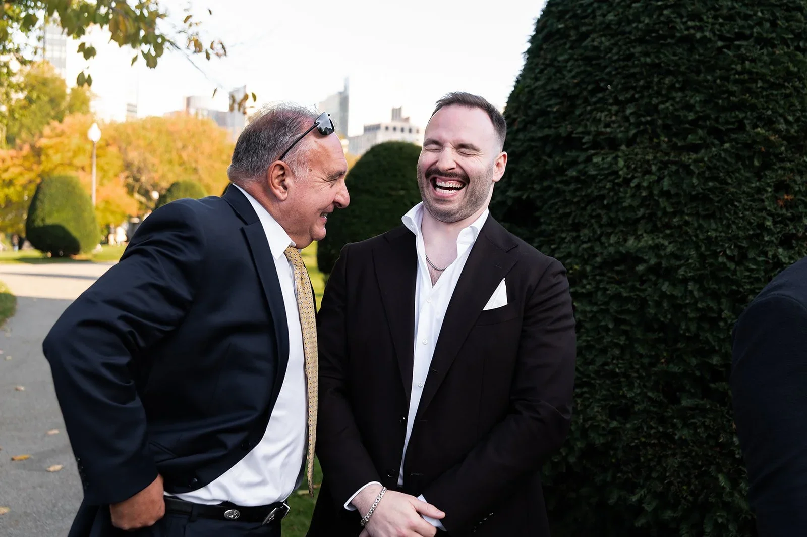 groom and father of bride laughing in boston public garden