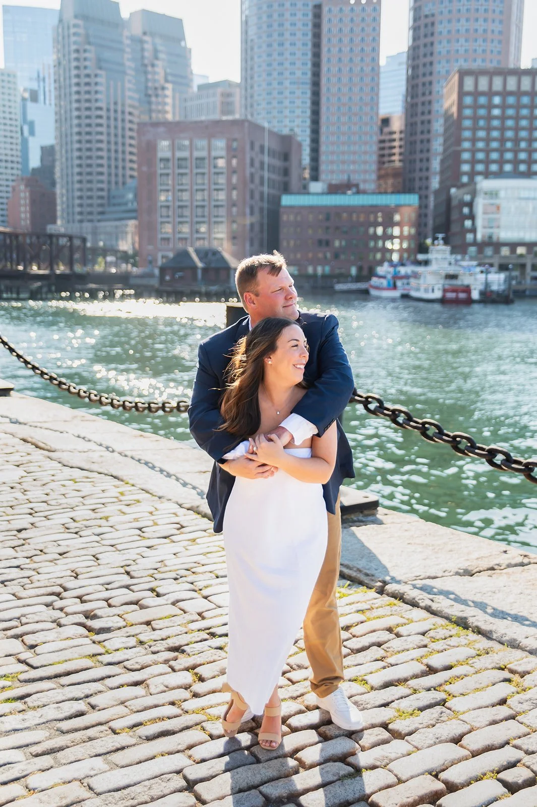 Couple looking out at the water at Fan Pier Park in Boston during engagement photos