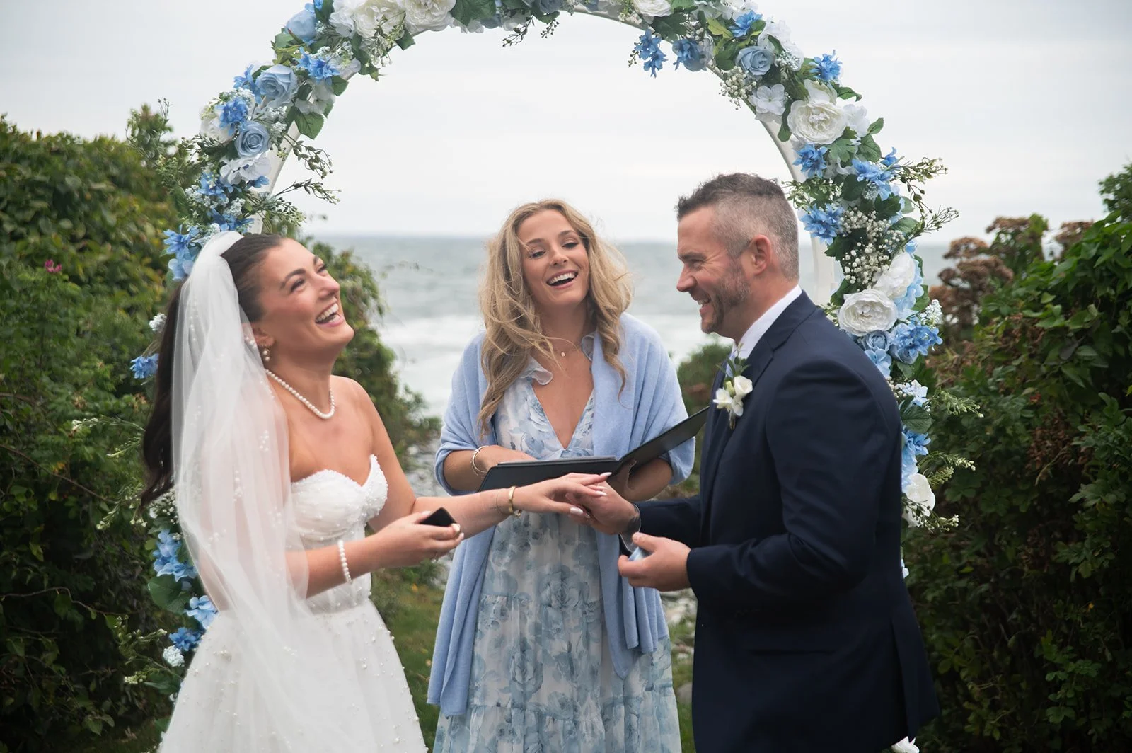 bride and groom laughing during oceanside micro wedding ceremony