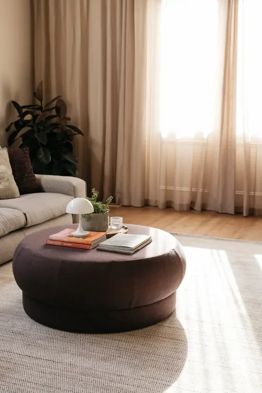 A round coffee table adding serving as a focal piece to a minimalist living area.