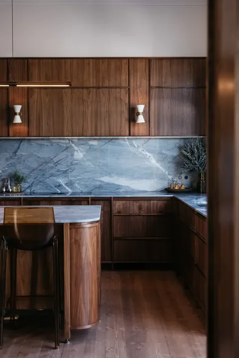 A minimalist kitchen with wooden cabinets and grey marble countertops, designed by Hygge Design, which offers home interior design services in Melbourne