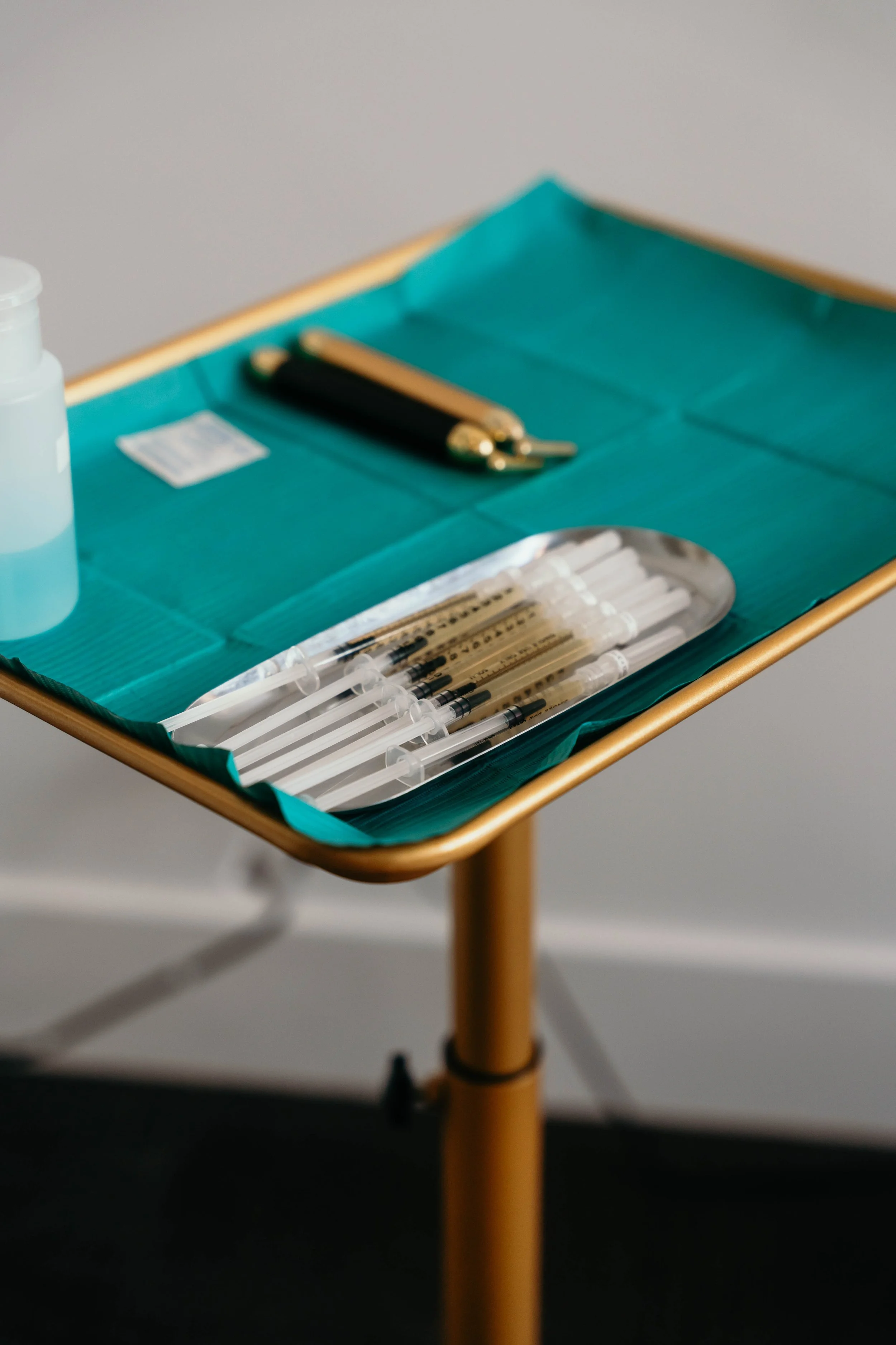 Medical tray with syringes and other tools on teal cloth