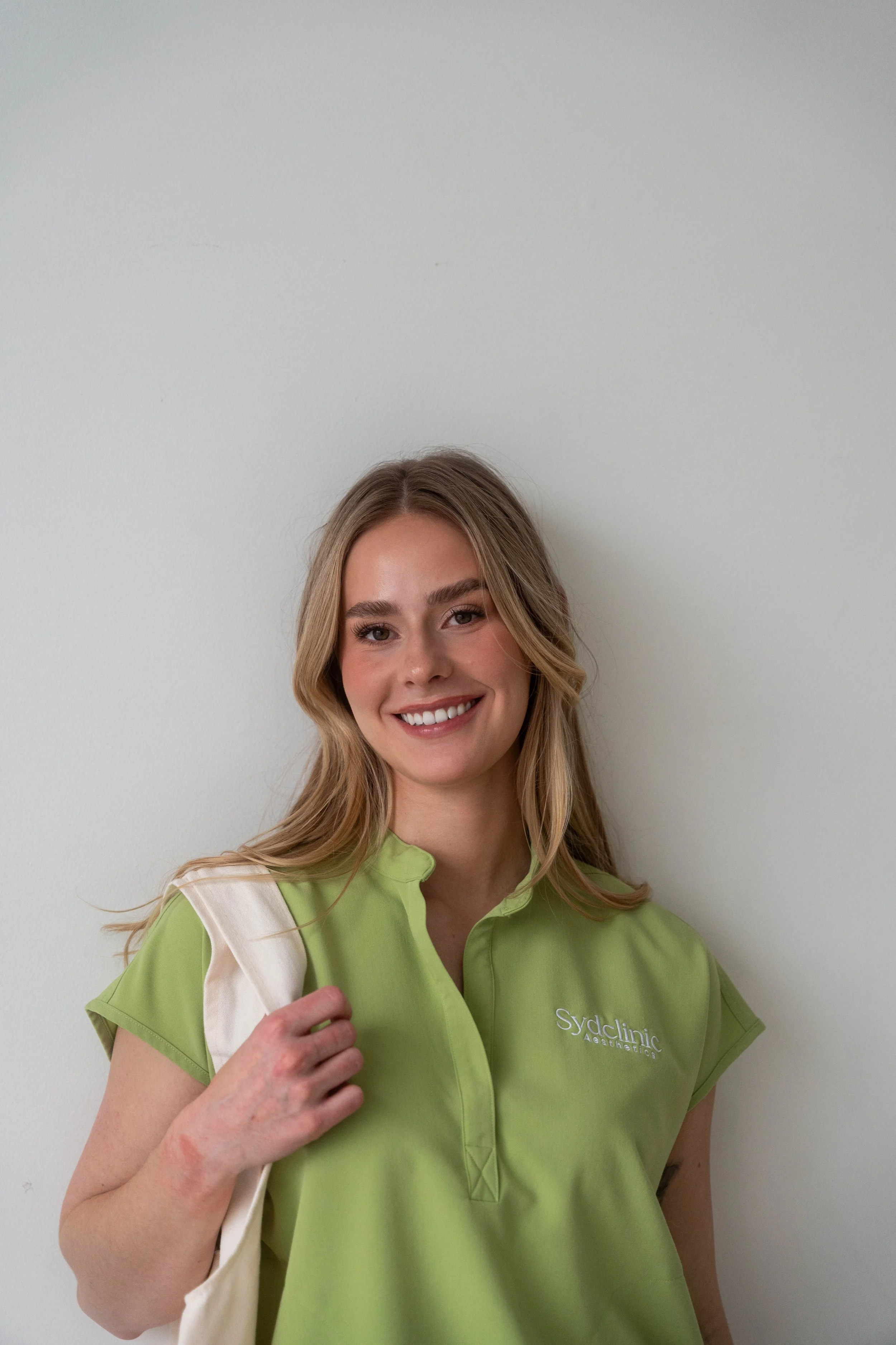Smiling woman with long blonde hair in front of skincare products and "Vivier" sign.