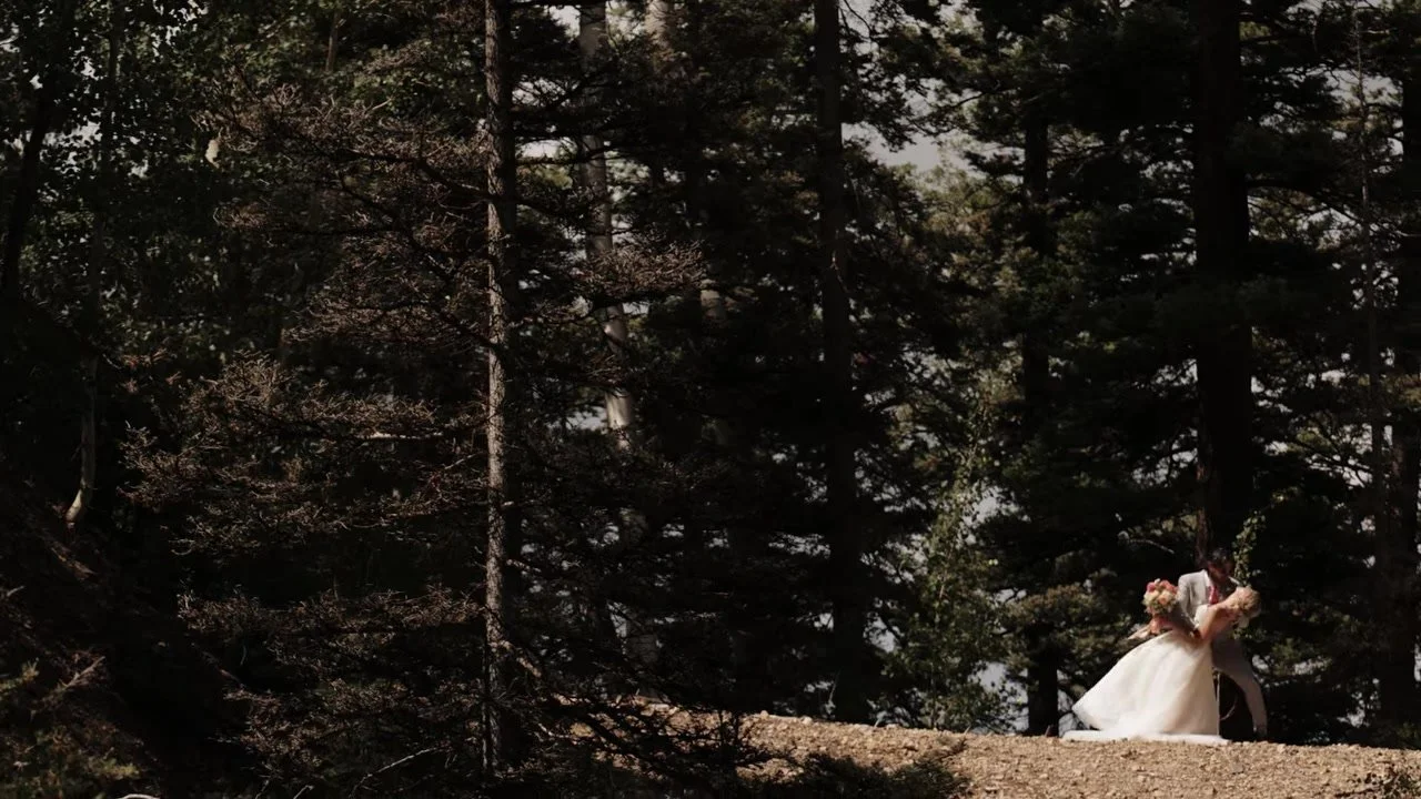 Brandon dipping Madeline on a sunlit forest path below Gold Mountain