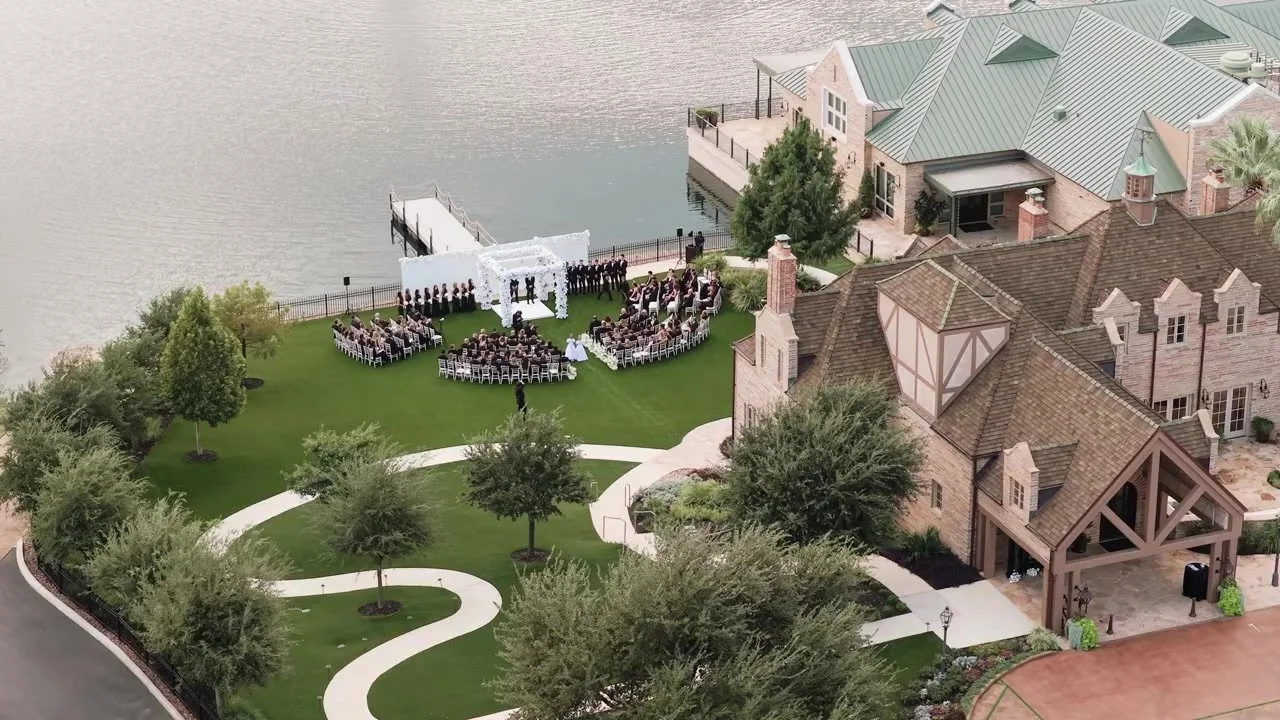 Aerial view of the lakeside ceremony and stone mansion at Red Berry Estate in San Antonio