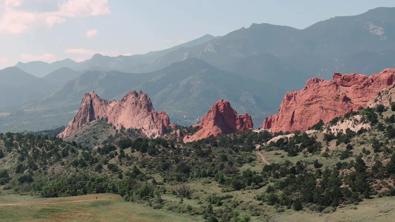 Wide landscape of Garden of the Gods red rocks and distant Pikes Peak