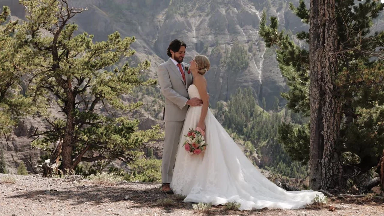 Madeline and Brandon on a gravel path with San Juan cliffs behind them at Gold Mountain